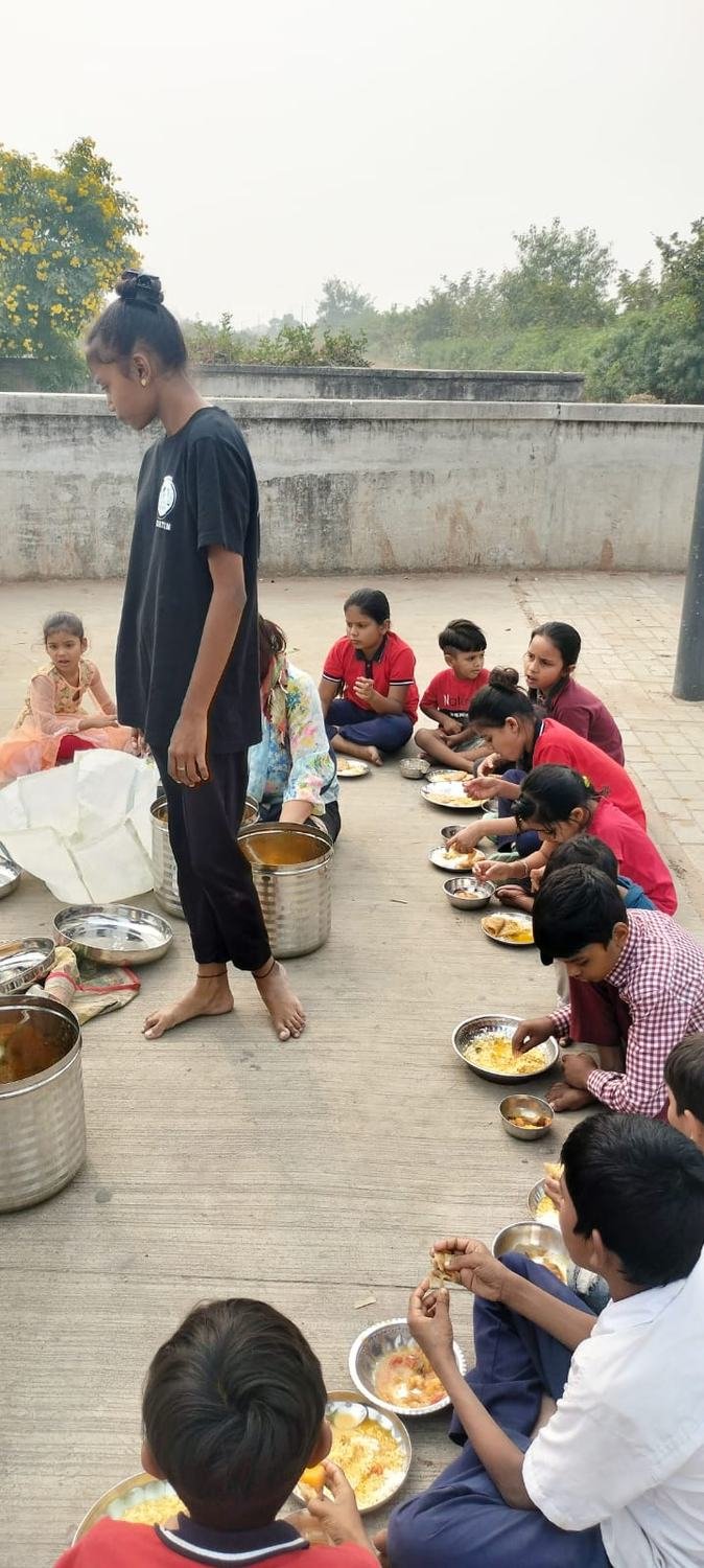 Volunteers serving hot food to children on the roadside